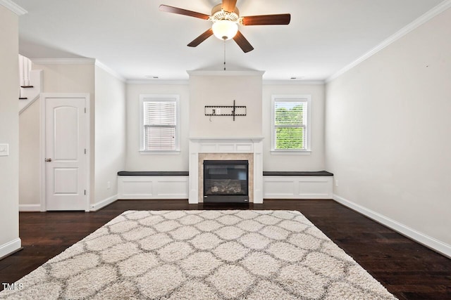 unfurnished living room featuring ceiling fan, wood finished floors, baseboards, ornamental molding, and a fireplace