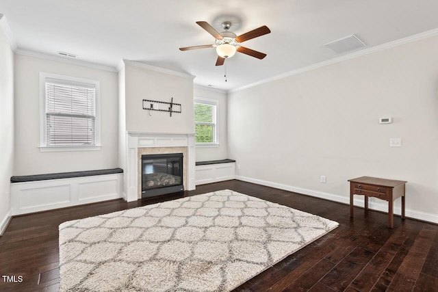 living area with dark wood-type flooring, a ceiling fan, ornamental molding, baseboards, and a tile fireplace