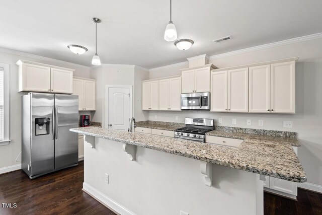 kitchen with appliances with stainless steel finishes, baseboards, white cabinets, a kitchen breakfast bar, and ornamental molding