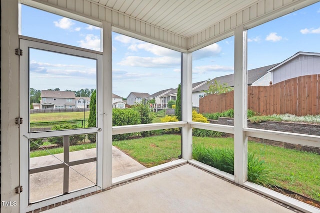 unfurnished sunroom featuring a residential view and healthy amount of natural light