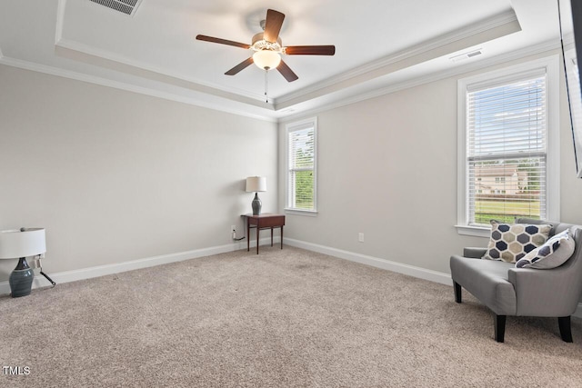 living area with a raised ceiling, crown molding, a ceiling fan, carpet, and baseboards