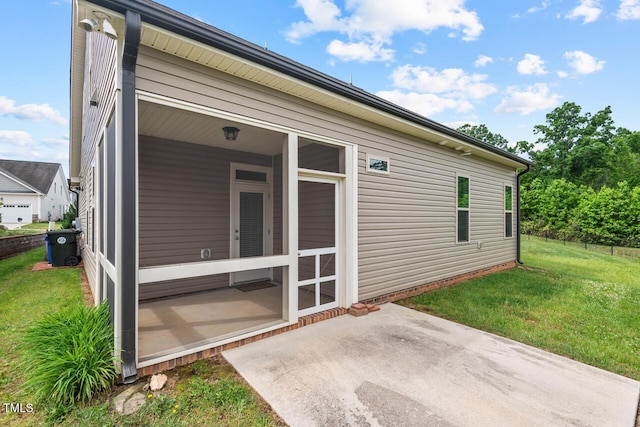 back of house featuring a patio, a yard, and a sunroom