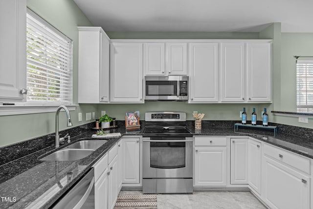 kitchen featuring a sink, stainless steel appliances, white cabinetry, and a healthy amount of sunlight