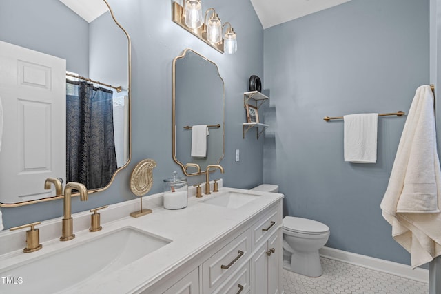 bathroom featuring a sink, tile patterned flooring, toilet, and double vanity