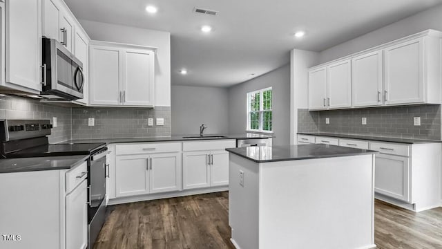 1005 Ocean Ct, Carthage, NC 28327 - kitchen featuring stainless steel appliances, a peninsula, dark wood-style flooring, dark countertops, and recessed lighting