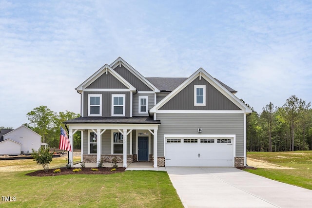 craftsman-style house with a garage, a porch, a front yard, and concrete driveway