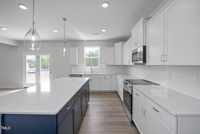 kitchen featuring tasteful backsplash, recessed lighting, appliances with stainless steel finishes, white cabinets, and a sink