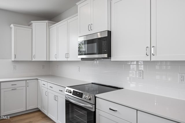 kitchen featuring white cabinetry, stainless steel appliances, and light countertops