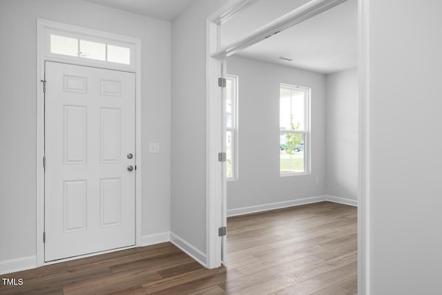 entryway with baseboards, visible vents, and wood finished floors