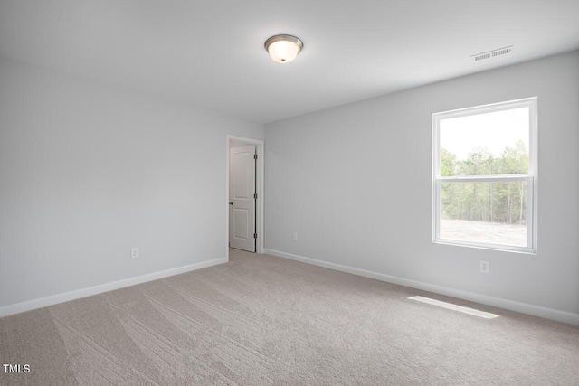 carpeted spare room with visible vents and baseboards