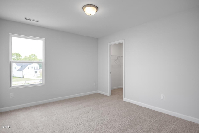 carpeted spare room featuring baseboards and visible vents