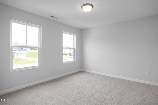 carpeted empty room featuring visible vents and baseboards