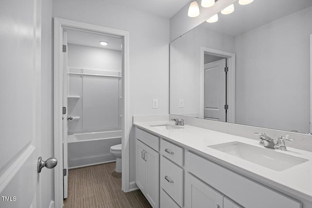 full bathroom with double vanity, toilet, and a sink