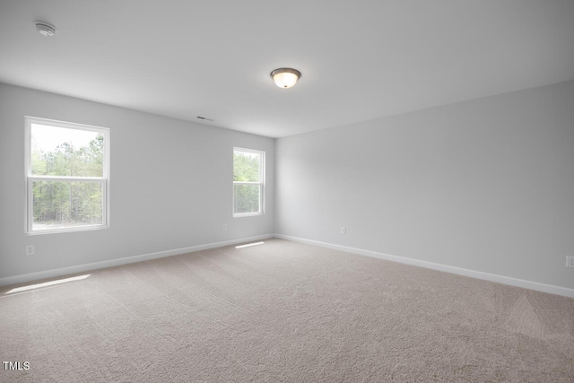 empty room with carpet and baseboards