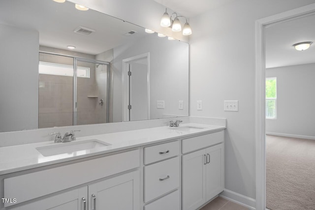 bathroom featuring baseboards, visible vents, a stall shower, and a sink