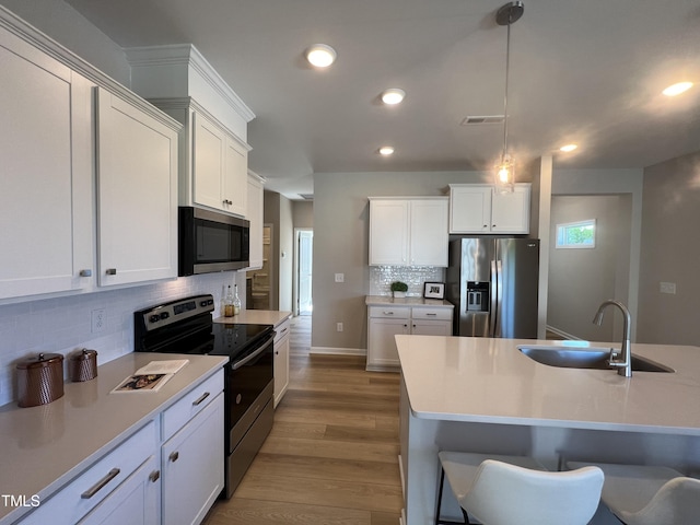 228 Pecan Valley Way, Four Oaks, NC 27524 - kitchen featuring appliances with stainless steel finishes, a sink, tasteful backsplash, wood finished floors, and recessed lighting