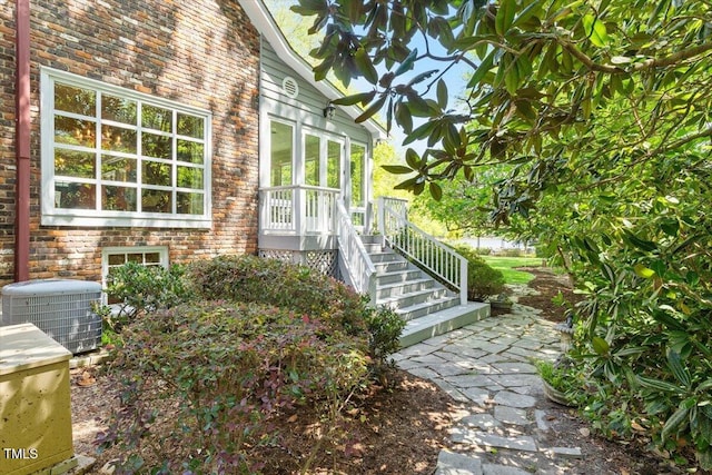 entrance to property with cooling unit and brick siding
