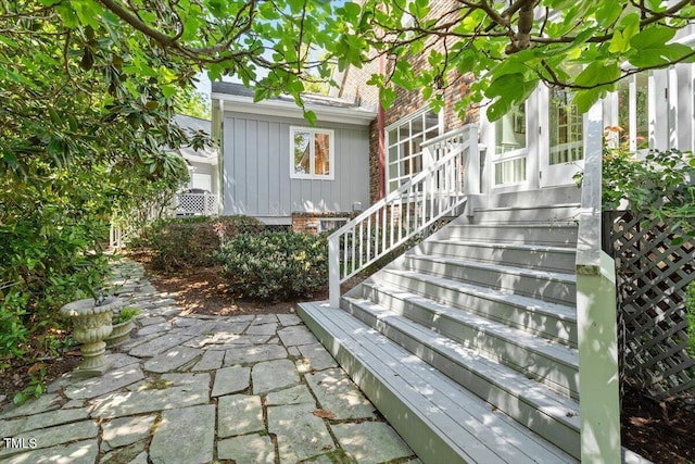view of exterior entry with brick siding and board and batten siding