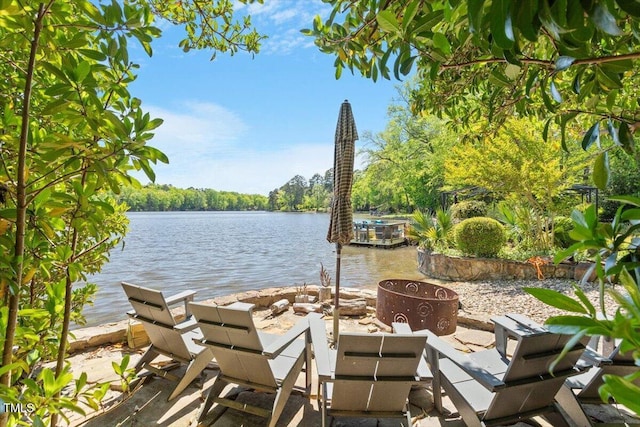 view of patio / terrace with a fire pit and a water view
