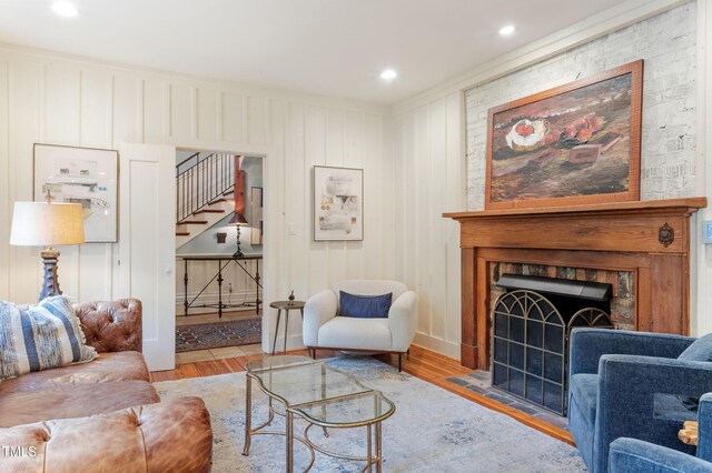 living room with stairs, wood finished floors, a fireplace, recessed lighting, and baseboards