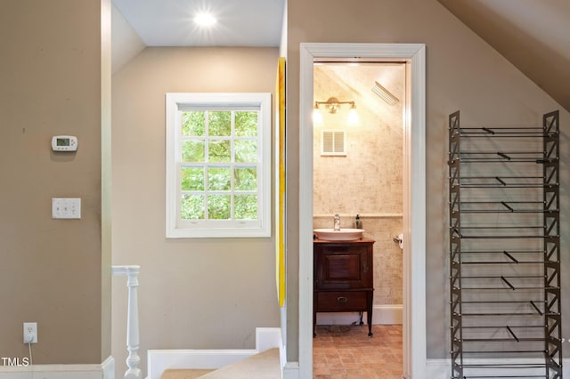 bathroom featuring lofted ceiling, vanity, and baseboards