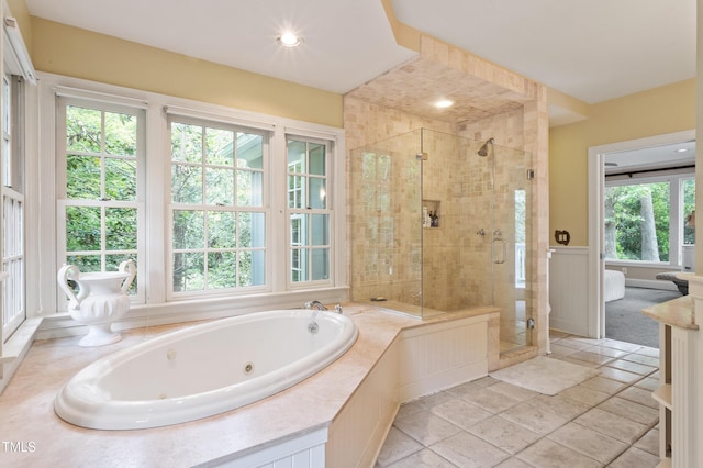 full bathroom featuring a tub with jets, a stall shower, and wainscoting