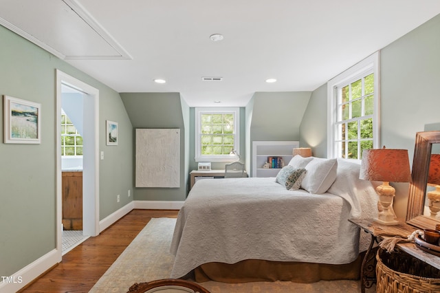 bedroom featuring attic access, wood finished floors, baseboards, lofted ceiling, and recessed lighting