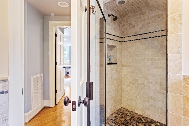 bathroom with a shower stall and wood finished floors