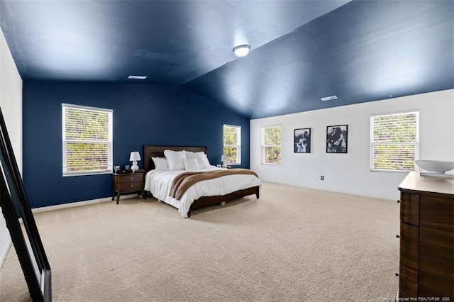 carpeted bedroom with baseboards, multiple windows, and lofted ceiling