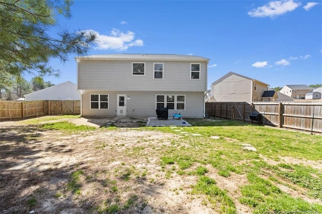 back of house with a yard, a fenced backyard, and a patio area