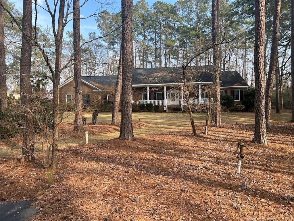 ranch-style house with roof with shingles and covered porch