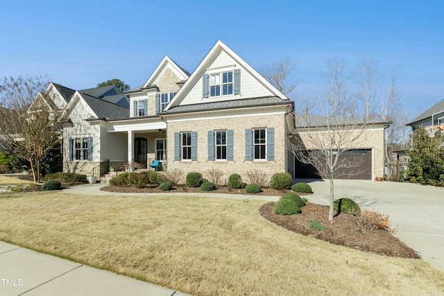 view of front of house featuring brick siding, an attached garage, concrete driveway, and a front yard