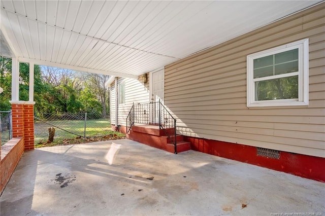 view of patio featuring an attached carport and fence