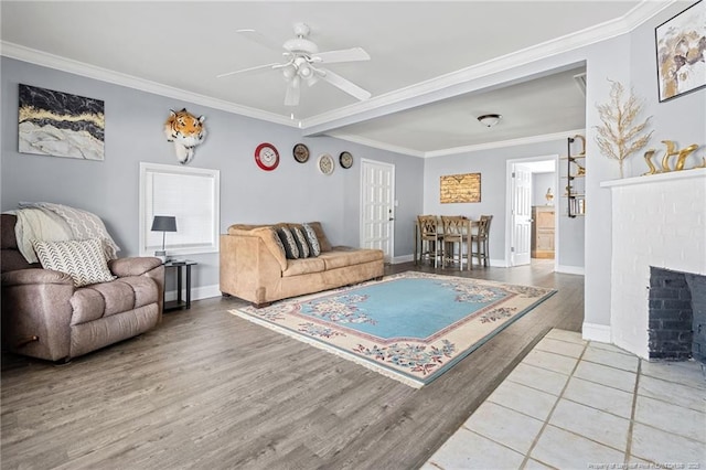 living room featuring wood finished floors, ornamental molding, and a ceiling fan