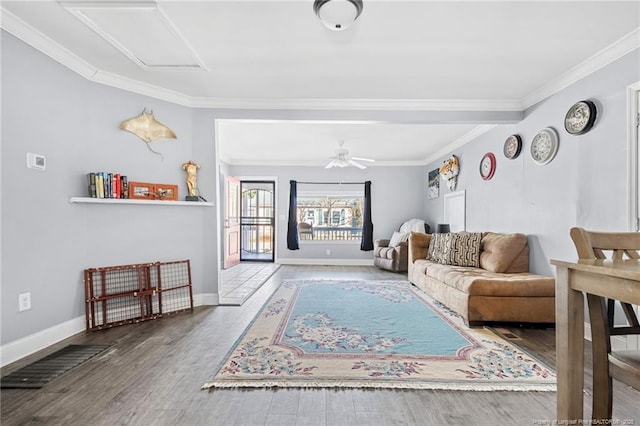 living room featuring visible vents, baseboards, wood finished floors, and crown molding