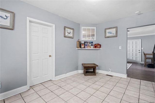 interior space featuring light tile patterned floors, visible vents, and baseboards