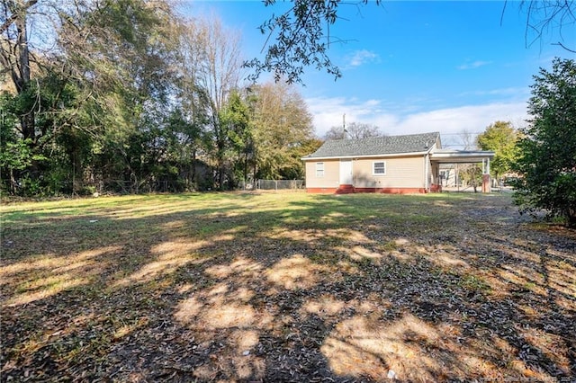 view of yard with a carport and fence