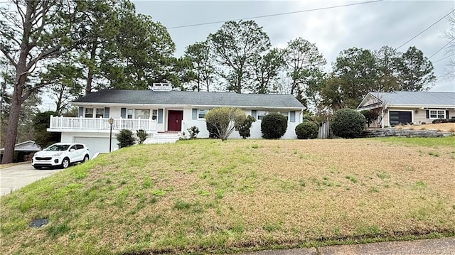 ranch-style house with driveway, an attached garage, and a front lawn