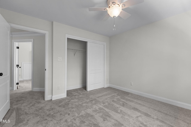 unfurnished bedroom with carpet, a closet, a ceiling fan, and baseboards