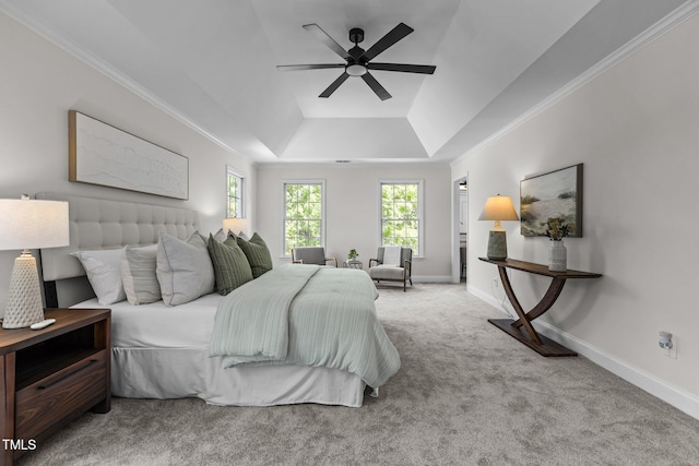 bedroom with a tray ceiling, carpet, crown molding, and baseboards