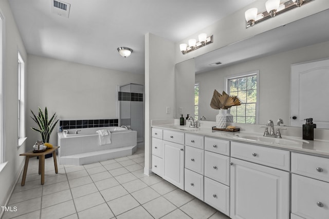 full bath with double vanity, a bath, tile patterned flooring, and a sink