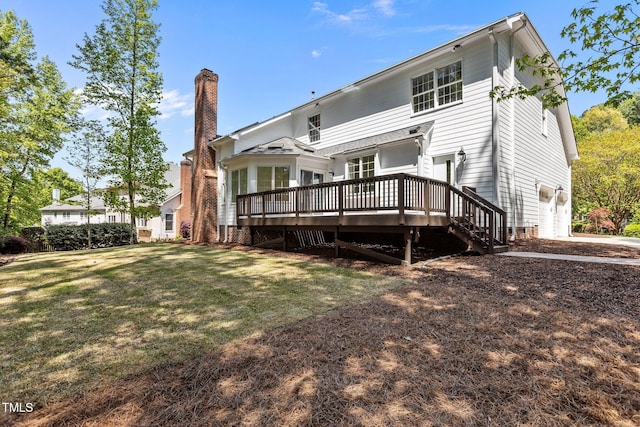 rear view of property featuring a chimney, a yard, a garage, a wooden deck, and stairs