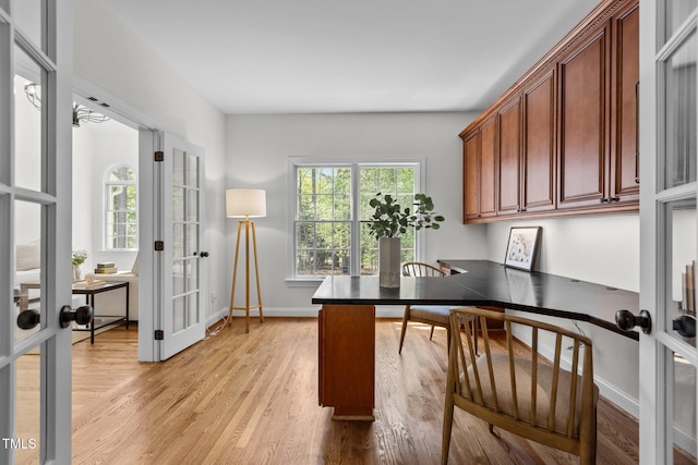 office area featuring light wood-type flooring, french doors, and baseboards