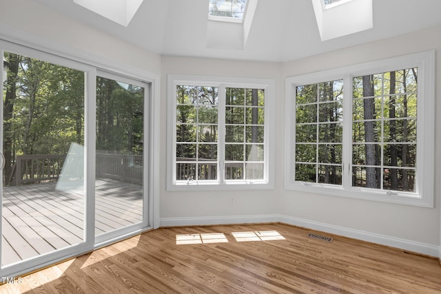 unfurnished sunroom with visible vents and a skylight