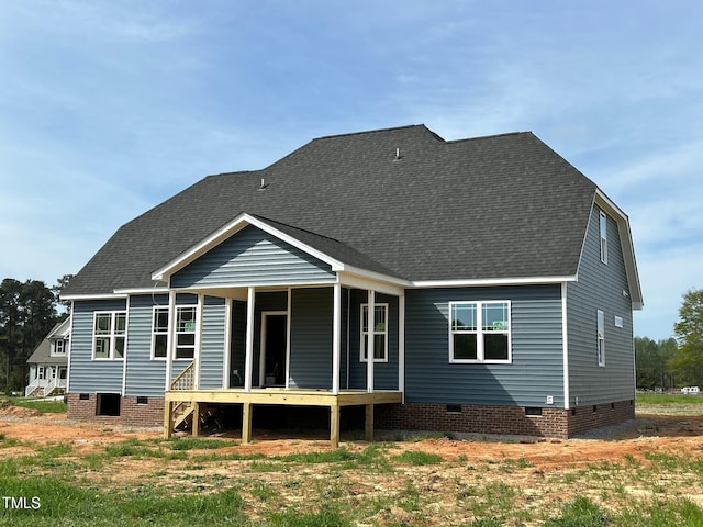 rear view of house with crawl space and a shingled roof