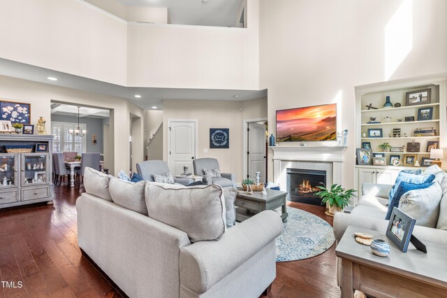 50 Lockamy Ln, Youngsville, NC 27596 - living room with a lit fireplace, an inviting chandelier, dark wood finished floors, and a towering ceiling