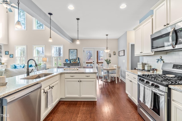 50 Lockamy Ln, Youngsville, NC 27596 - kitchen featuring dark wood-style flooring, a sink, appliances with stainless steel finishes, white cabinetry, and backsplash