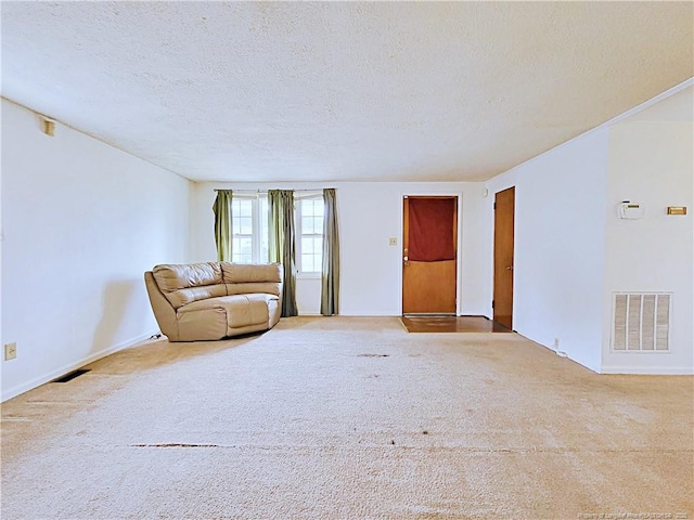 unfurnished living room with visible vents, carpet floors, and a textured ceiling