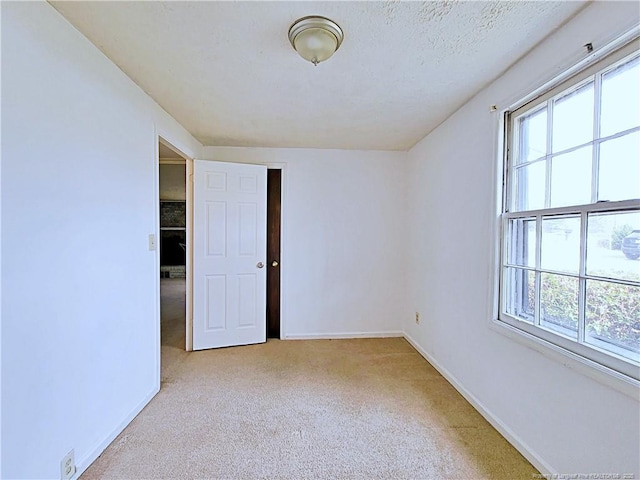 spare room with baseboards and carpet