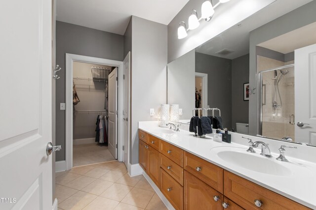 340 Allister Dr Unit 201, Raleigh, NC 27609 - bathroom with a walk in closet, a sink, tile patterned flooring, double vanity, and a shower stall